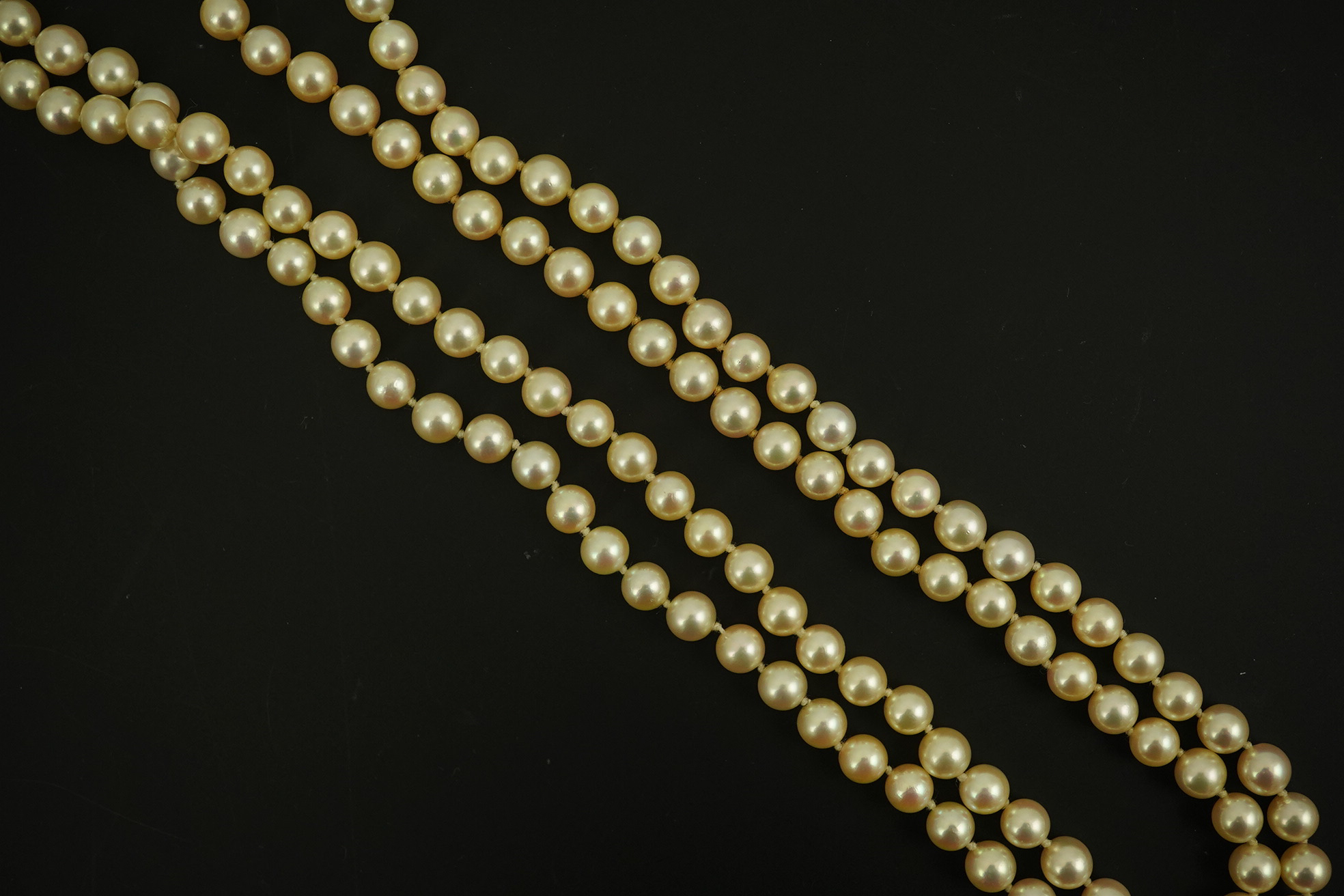 A modern double strand cultured pearl necklace, with 18k gold and diamond set twin ring clasp